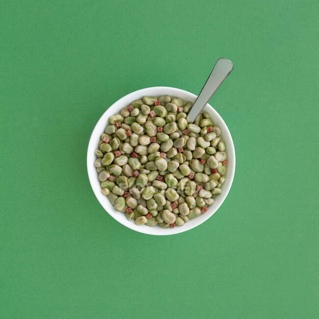 Vue du dessus des fèves surgelées dans un bol servi sur une table verte — Photo de stock