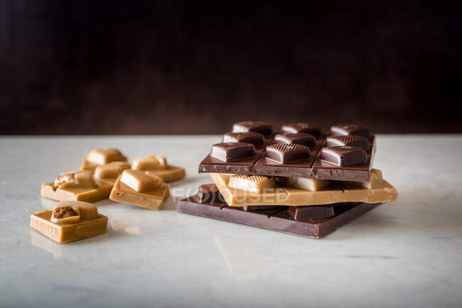 Смачні шоколадні цукерки з горіхами у формі серця, розкиданими на білому тлі. — стокове фото