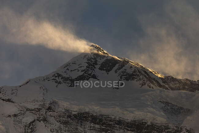 Montagnes rocheuses de l'Himalaya couvertes de neige éclairée par la lumière du soleil au Népal — Photo de stock