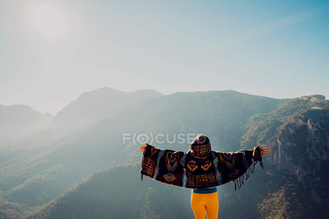 Vista posteriore di irriconoscibile esploratrice spensierata in piedi con le braccia tese negli altopiani e godendo della libertà — Foto stock