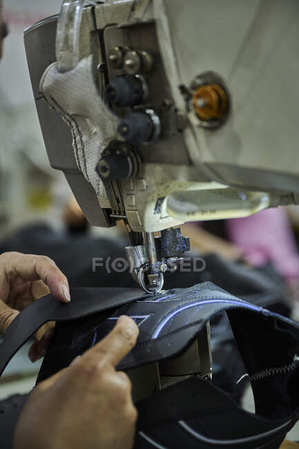 Detail of worker's hands doing sewing in the leather of the shoes at Chinese shoes factory — Stock Photo