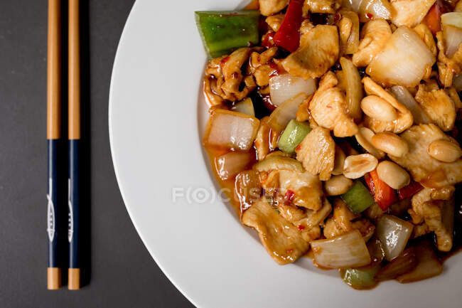 Vue aérienne du plat de délicieux poulet Gong Bao sur fond noir au restaurant — Photo de stock