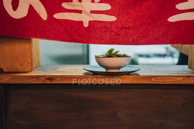Prato asiático tradicional em tigela de cerâmica branca na janela de madeira no restaurante — Fotografia de Stock