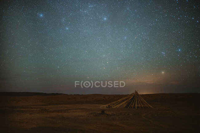Céu estrelado brilhante sobre o deserto pacífico e abrigo pobre à noite em Marraquexe, Marrocos — Fotografia de Stock