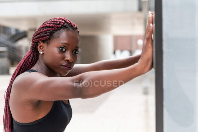 Woman leaning at wall during workout — Stock Photo