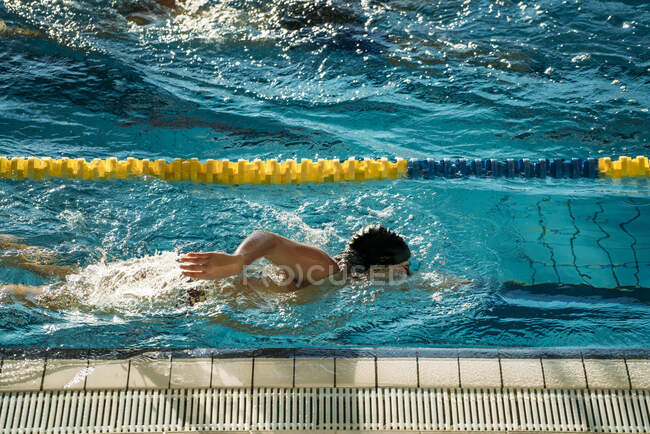 Бічний вид паралімпійських спортсменів в окулярах і шапці без ручного плавання в басейні між смугами — стокове фото