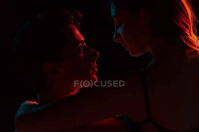 Artistic image of affectionate couple showing love under projector lights — Stock Photo