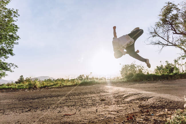 Akrobatische Männersprünge über dem Boden und gefährliche Parkour-Kunststücke an sonnigen Tagen — Stockfoto