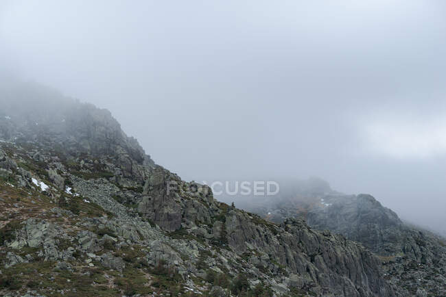 Calm landscape with mountain range covered with fog against cloudy morning sky in Guadarrama National Park in Madrid, Spain — Stock Photo