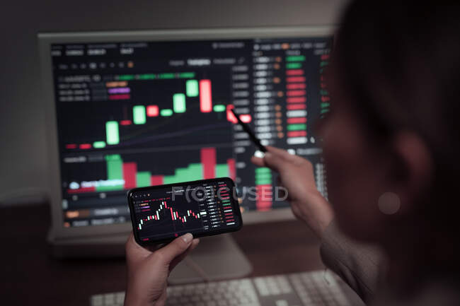 Faceless crop broker using mobile phone while working with financial chart during trading — Stock Photo