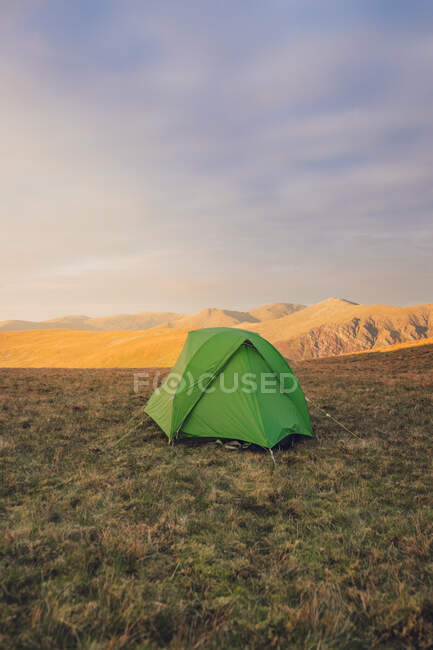 На заході сонця в Уельсі зелений табір розміщений на трав 