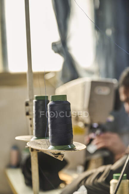 Detalhe de pacotes de fios na máquina de costura na fábrica de sapatos chineses — Fotografia de Stock