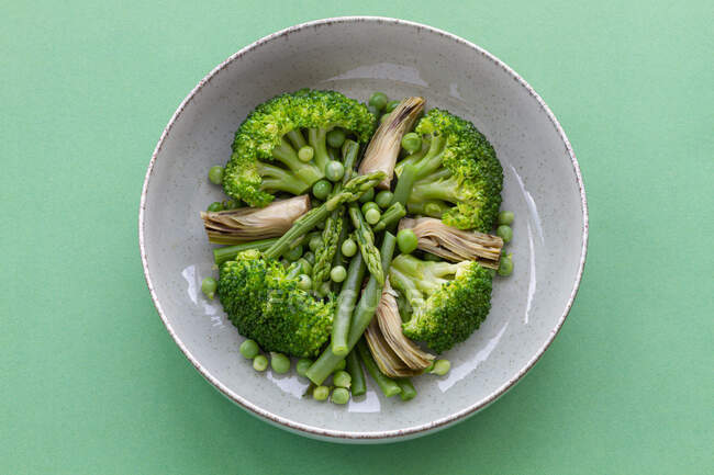 Вид сверху на овощное блюдо с брокколи, грибами и горохом — стоковое фото