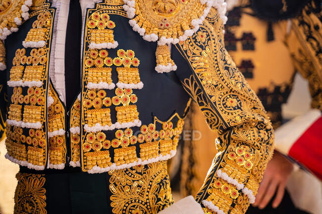 Crop unrecognizable bullfighters in traditional costume decorated with embroidery preparing for corrida festival — Stock Photo