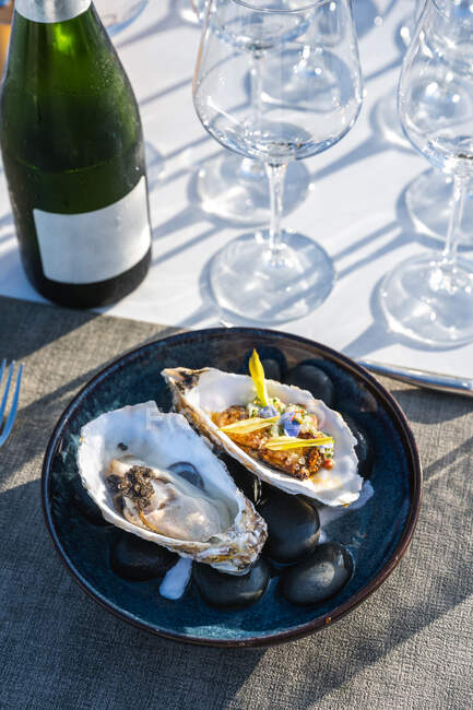 Delizioso e ben decorato piatto di ostriche in coppia con champagne al ristorante di alta cucina all'aperto — Foto stock