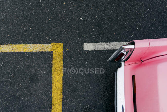 Вид зверху на деталь заднього плану класичного рожевого автомобіля на асфальтовому ґрунті — стокове фото