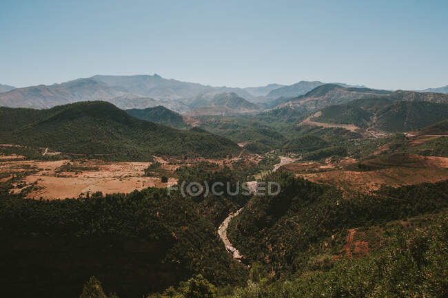 Сверху живописный пейзаж зеленой холмистой долины с лесом и дорогами в Марокко, Марракеше, Африке — стоковое фото