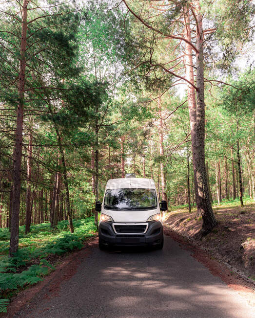 Viajando campista estacionado na estrada de asfalto em bosques no dia ensolarado no verão — Fotografia de Stock