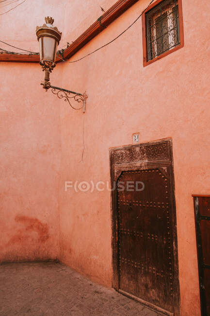Parete sgretolante di vecchia casa con vecchia porta sulla strada di Marrakech, Marocco — Foto stock