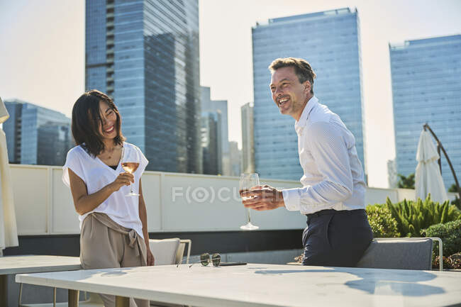 Designer et compagnon de travail après le travail ayant du temps de détente dans une terrasse à côté des immeubles de bureaux, ils ont une tasse de vin blanc — Photo de stock