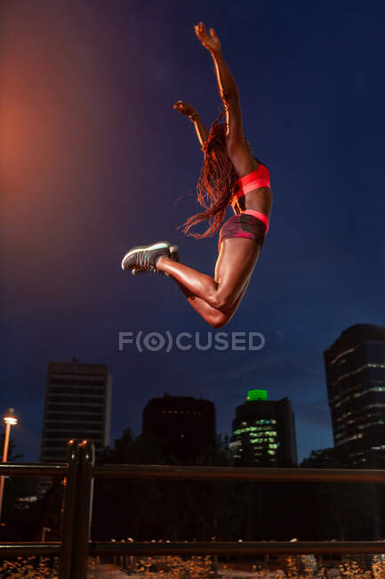 Atleta étnico pulando na rua — Fotografia de Stock