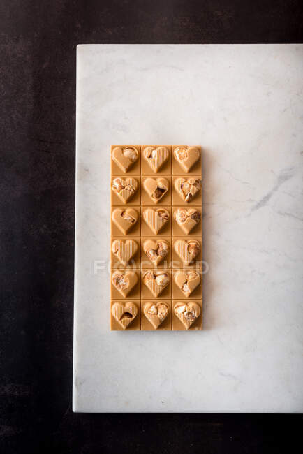 Draufsicht auf köstliche Bonbons mit Nüssen in Herzform auf weißem Hintergrund — Stockfoto