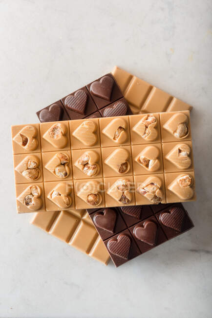 Vista superior de deliciosos doces de chocolate com nozes em forma de coração no fundo branco — Fotografia de Stock