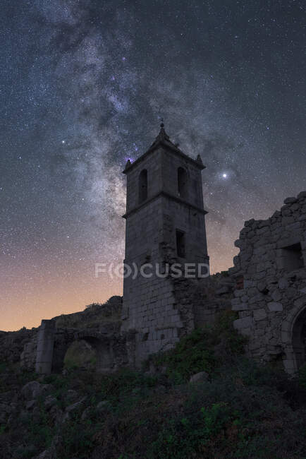 Amazing scenery with aged stone chapel in mountainous valley under evening sky with Milky Way and sunset light — Stock Photo