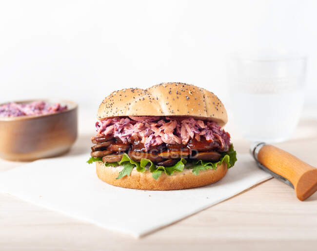 Вкусный веганский гамбургер с салатом и салатом в булочке с маком на столе — стоковое фото