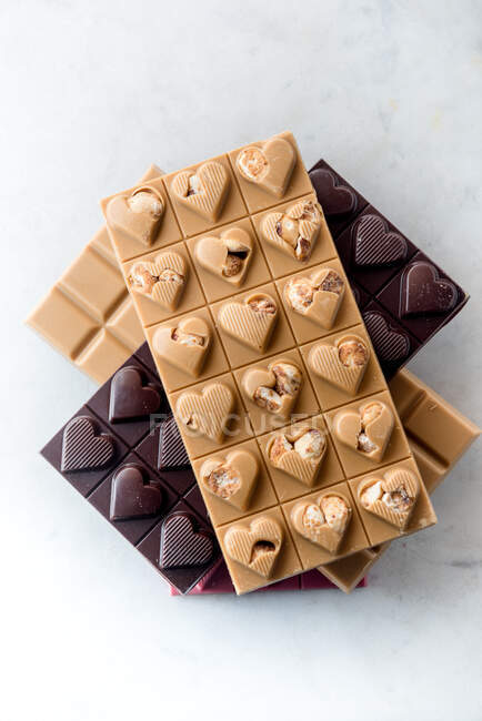 Vista superior de deliciosos caramelos de chocolate con nueces en forma de corazón sobre fondo blanco - foto de stock