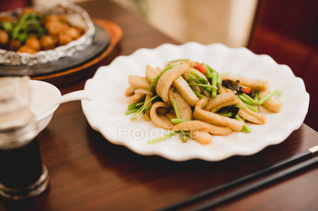 Dish of cooked delicious squid with vegetables in Asian cafe — Stock Photo