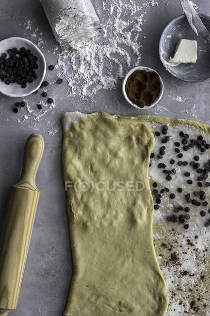 De dessus pâte fraîche pour la pâtisserie recouverte de farine dans la surface de la table en béton dans la cuisine confortable — Photo de stock