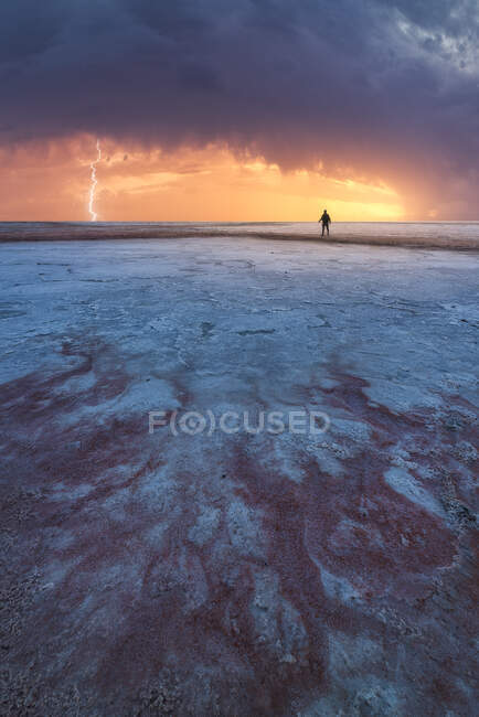 Silhueta pessoa irreconhecível na vista cênica da lagoa salgada localizada perto do mar em Penahueca sob o céu do pôr-do-sol — Fotografia de Stock