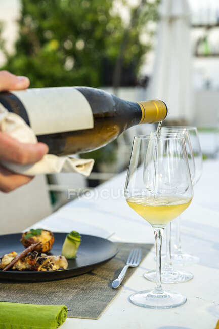 Garçom poiring vinho em um copo no restaurante de alta cozinha ao ar livre — Fotografia de Stock