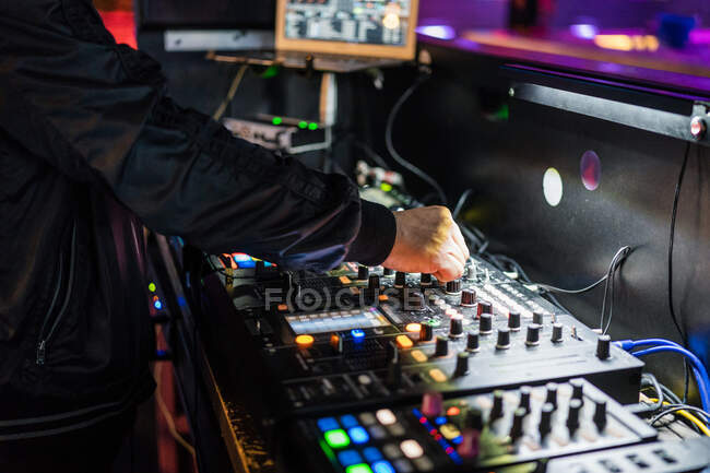 Из выше урожая человек играет профессиональные два канала DJ контроллер во время выступления на концерте в современном ночном клубе — стоковое фото