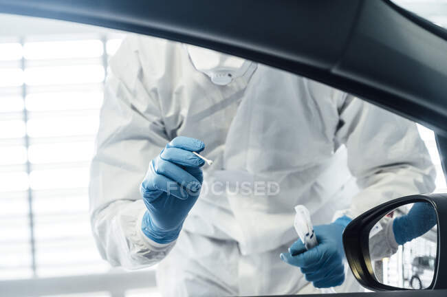 Biologo con guanti protettivi che esegue un test coronavirus su una persona in auto — Foto stock