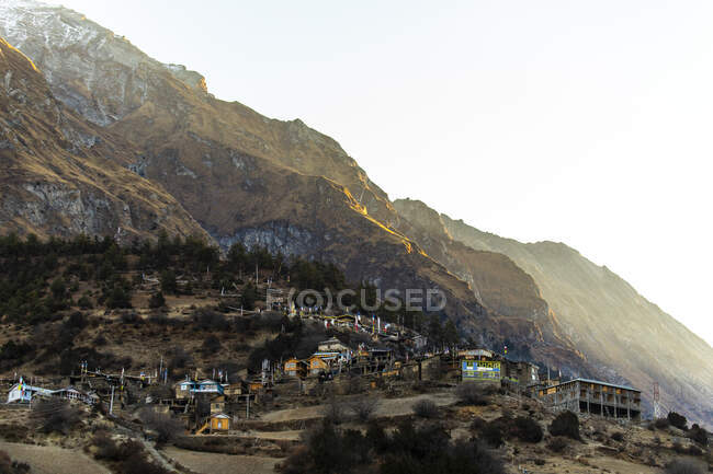 Majestuoso paisaje de asentamiento con casas residenciales ubicadas en ladera rocosa en el Himalaya en Nepal por la mañana - foto de stock
