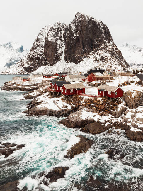 From above aerial view cabins located on mountain range snowy coast on Lofoten Islands, Norway — Stock Photo