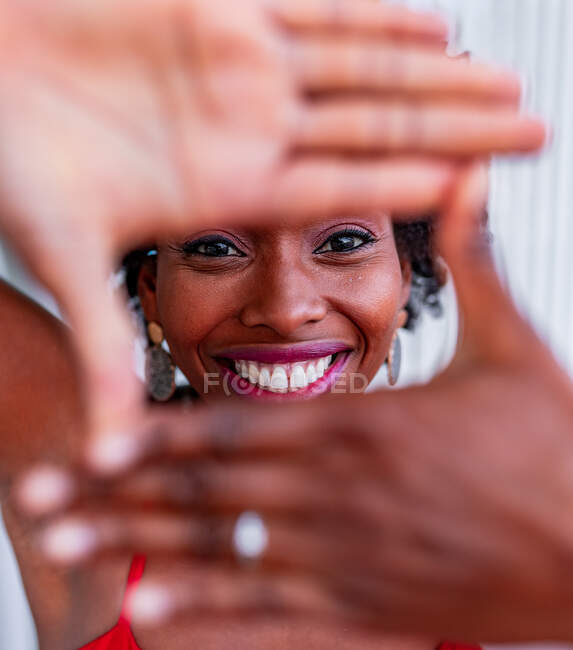 Afroamerikanerin demonstriert Foto-Geste mit den Händen, während sie in die Kamera schaut — Stockfoto