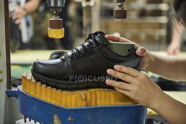 Détail des mains de la femme tout en vérifiant les chaussures dans la ligne de production de contrôle de qualité dans l'usine de chaussures chinoise — Photo de stock