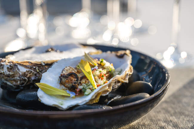 Delicioso y bien decorado plato de ostras en el restaurante de alta cocina al aire libre - foto de stock