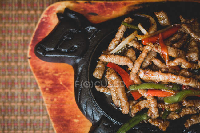 Tasty beef with vegetables placed on black plate — Stock Photo