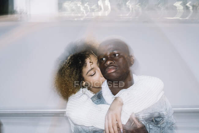 Молодая романтичная афроамериканка с вьющимися волосами целуется и обнимает красавчика-бойфренда, проводя время вместе на улице — стоковое фото