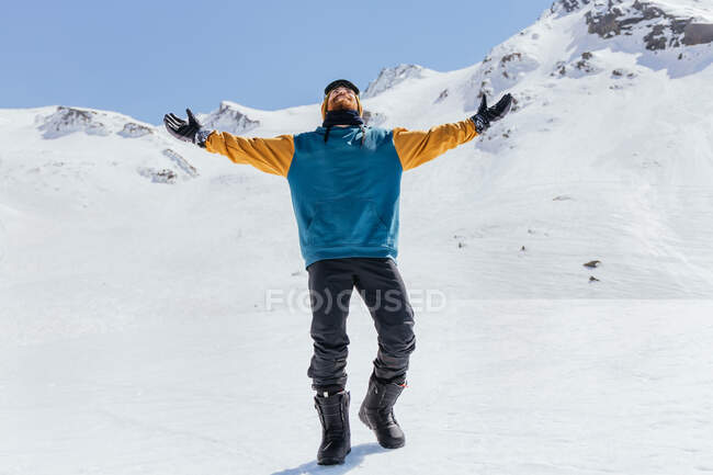 Cheerful male athlete in sportswear looking away against Sierra Nevada on sunny day in province of Granada Spain — Stock Photo