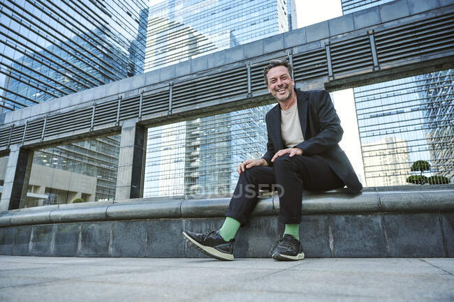 Designer sentado fora do prédio do escritório tendo descanso e sorrindo — Fotografia de Stock