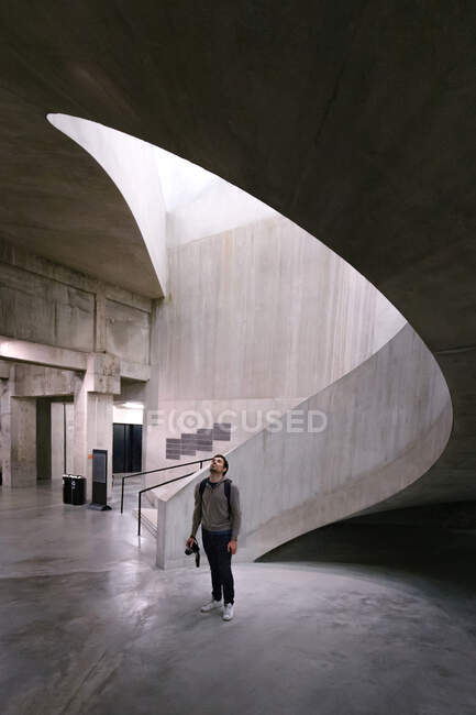 Distant man on concrete floor with futuristic staircase behind in Tate Gallery in London — Stock Photo