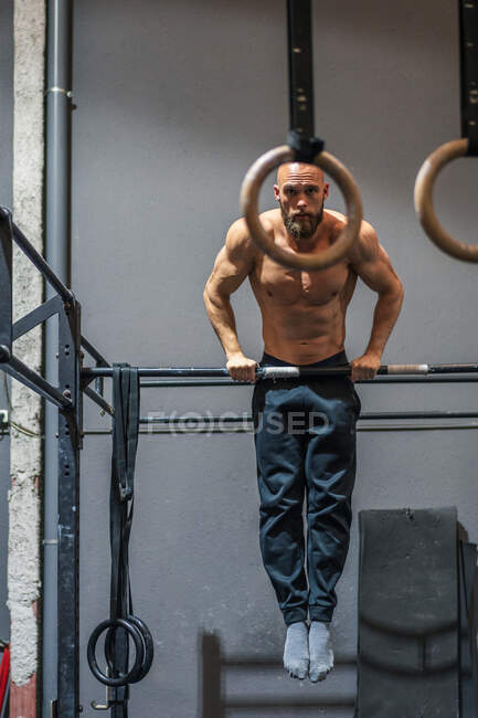 Full Body Shirtless Bearded Sportsman Hanging On Bar And Doing Pull Ups During Intense Training