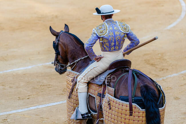Vista trasera de picador irreconocible con lanza a caballo durante corrida - foto de stock