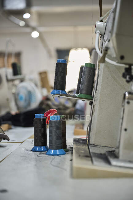 Detail of old sewing machine in a busy Chinese shoes factory — Stock Photo