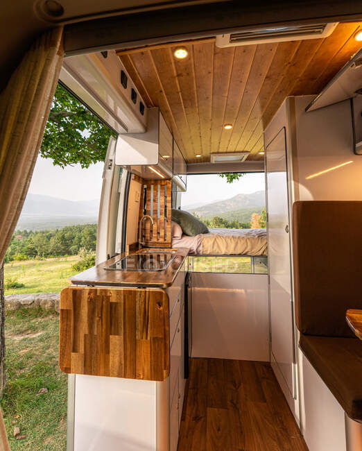 Сучасна кухня і спальня у фургоні припарковані на лузі. — стокове фото